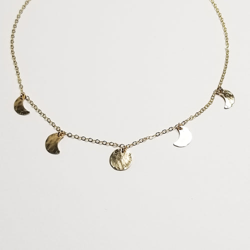 a yellow gold chain necklace with small moon pendants showing the moon phase on a gold chain with a white background