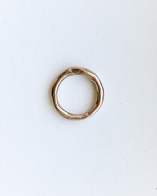 a hand formed bronze ring made from wax cast in metal shown on a white background