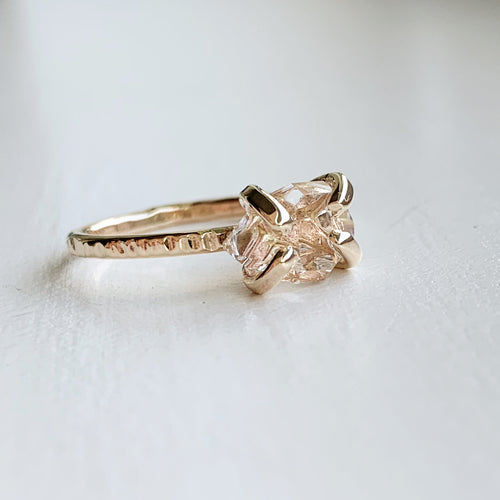 a solid gold claw style ring with a herkimer diamond on a white background